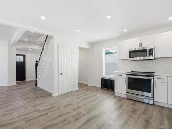 a view of a kitchen with a sink stove cabinets and empty room