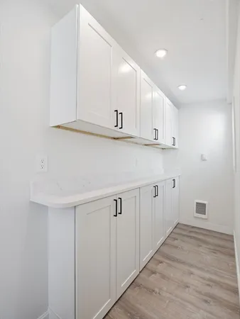 a kitchen with white cabinets and sink