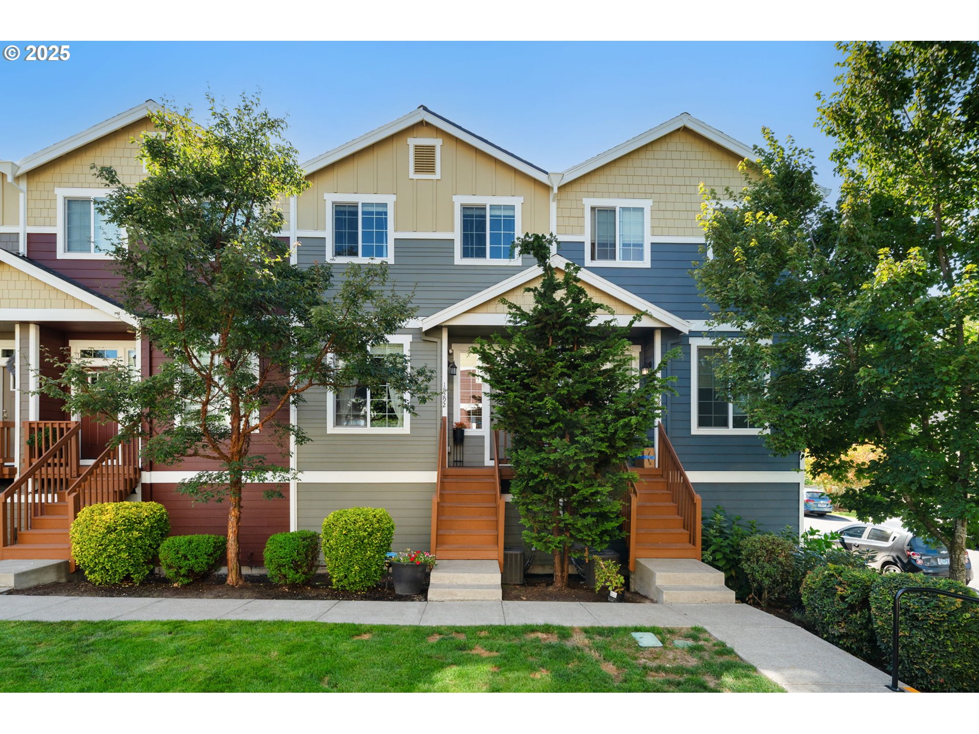 a front view of a house with a yard and potted plants