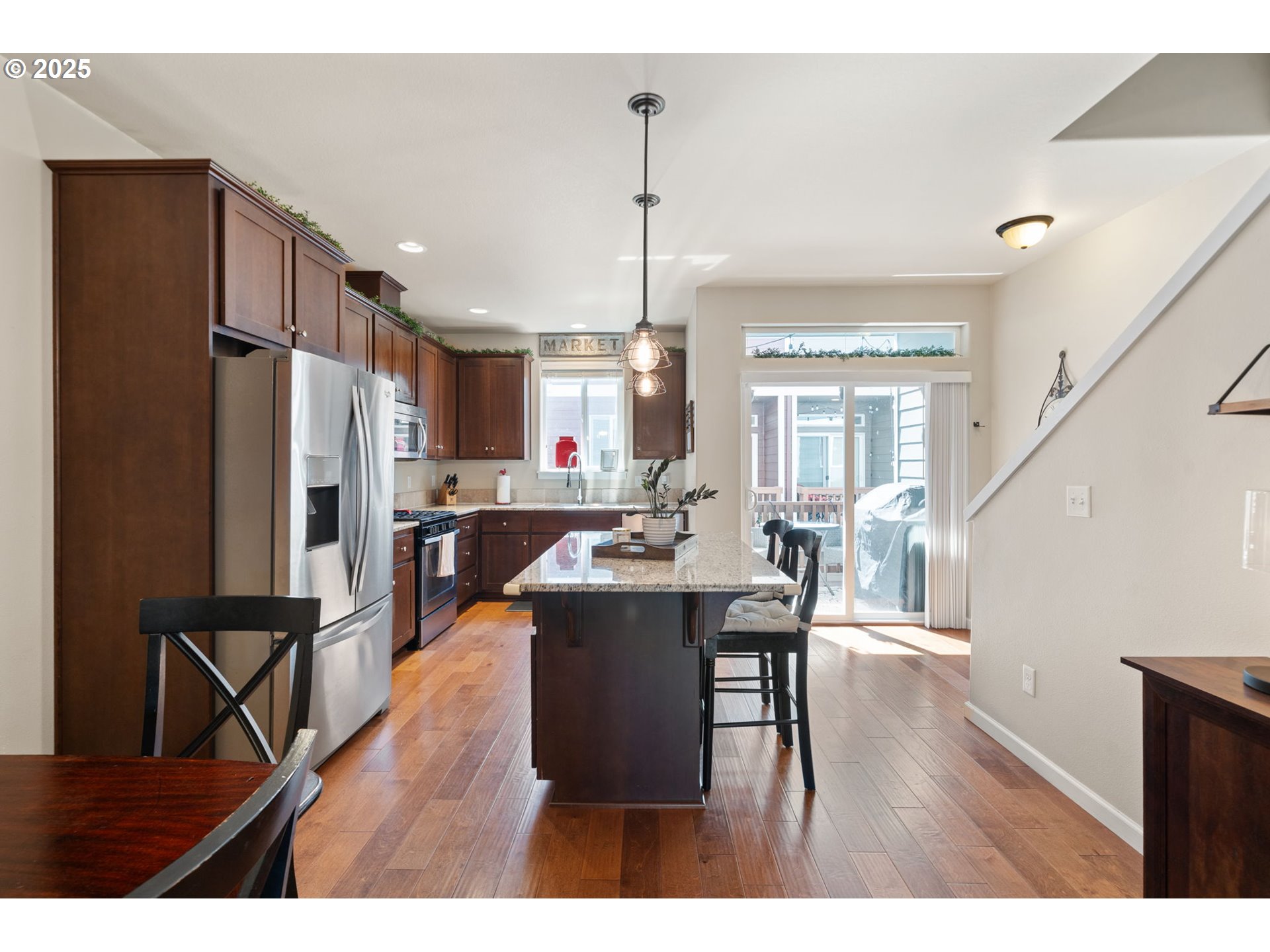 18292 Southwest Anna Mae Lane Beaverton, OR 97003 - Photo 12 of 34 a dining hall with stainless steel appliances kitchen island granite countertop a dining table chairs and a refrigerator
