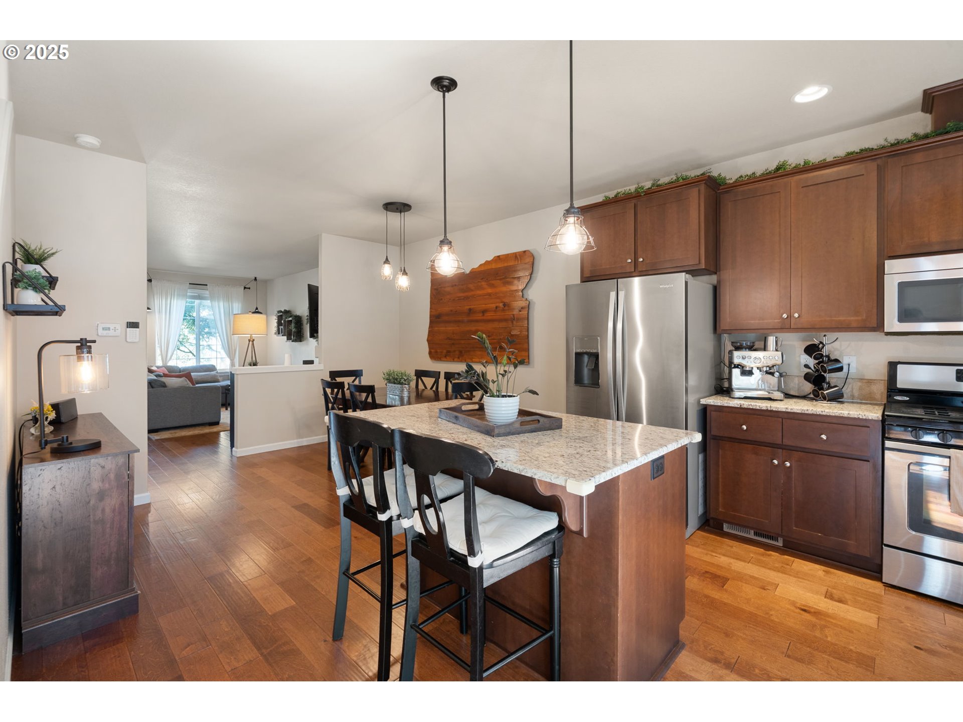 18292 Southwest Anna Mae Lane Beaverton, OR 97003 - Photo 13 of 34 a kitchen with stainless steel appliances kitchen island granite countertop a refrigerator a stove a kitchen island with a dining table and chairs