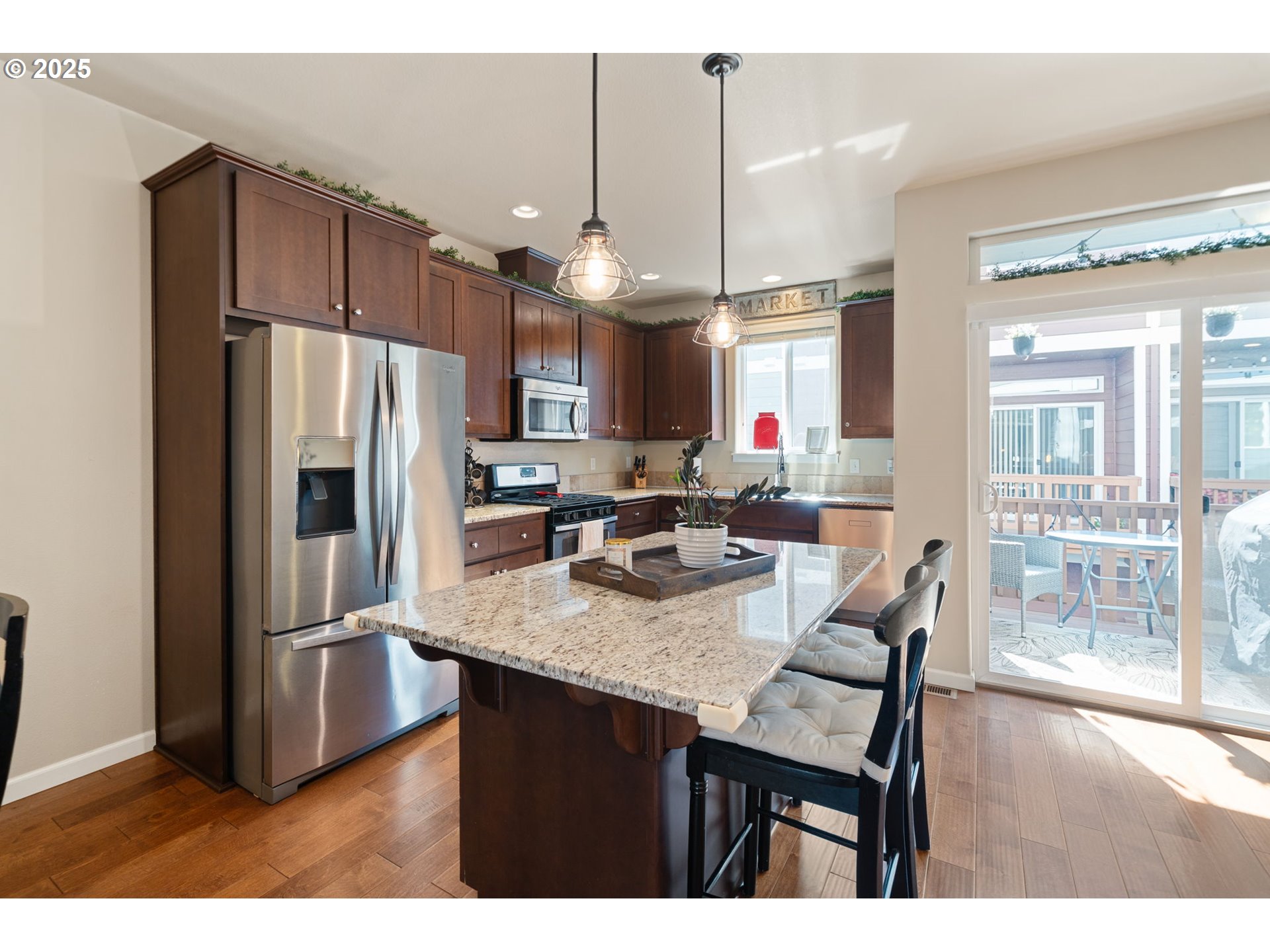 18292 Southwest Anna Mae Lane Beaverton, OR 97003 - Photo 16 of 34 a kitchen with stainless steel appliances granite countertop a refrigerator a sink dishwasher a dining table and chairs with wooden floor