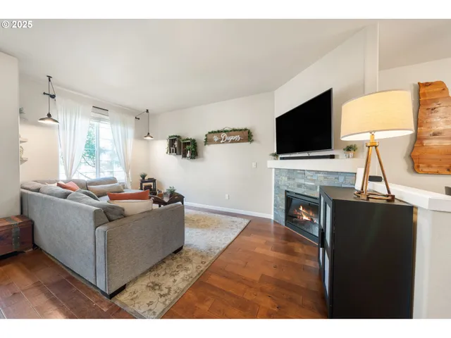 a living room with furniture a flat screen tv and a fireplace