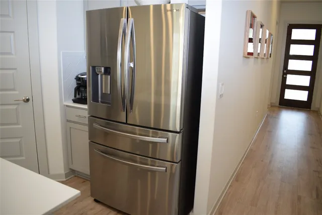 a kitchen with a dining table chairs microwave and refrigerator