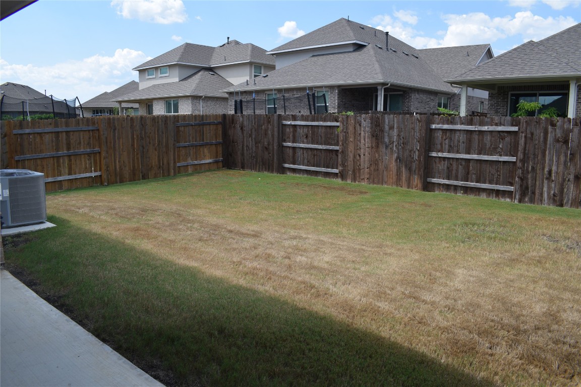 2409 Bear Cub Bend Leander, TX 78641 - Photo 21 of 37 a view of a house with a yard and wooden fence