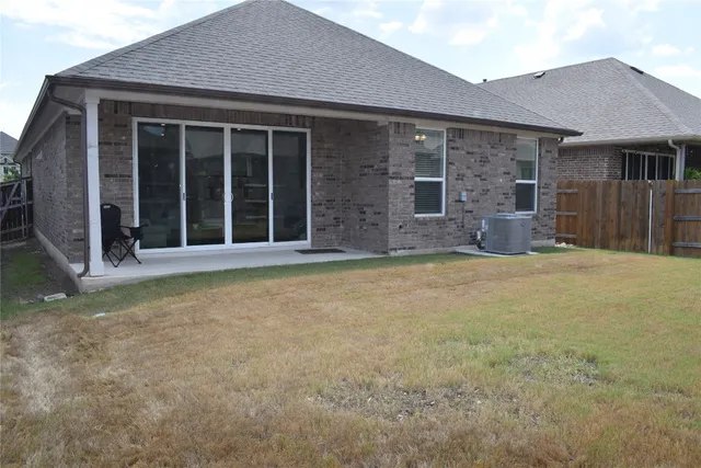 a view of a house with a yard and wooden fence