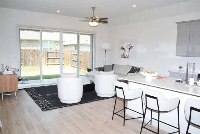 a living room with couches a coffee table and a chandelier with wooden floor