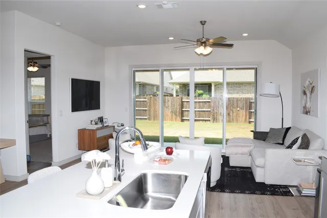 a living room with furniture a flat screen tv and a large window