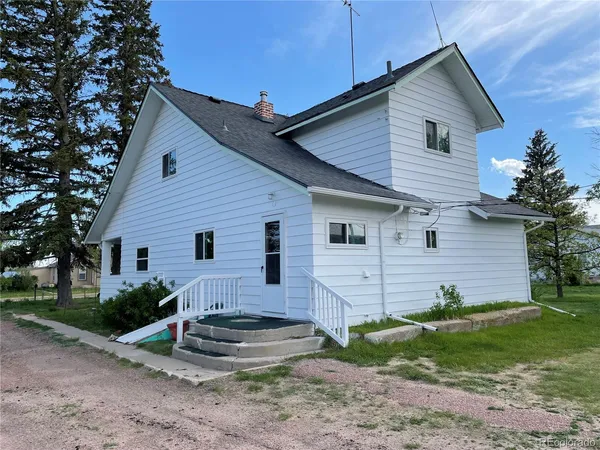 a view of house with a yard and front view of a house