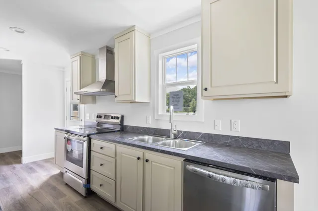 a kitchen with stainless steel appliances granite countertop a sink stove and refrigerator