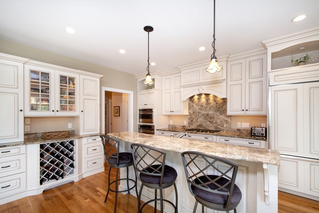 7 Tillinghast Drive, Unit 7 Hingham, MA 02043 - Photo 5 of 42 a kitchen with stainless steel appliances kitchen island granite countertop a stove a refrigerator a sink a dining table and chairs with wooden floor