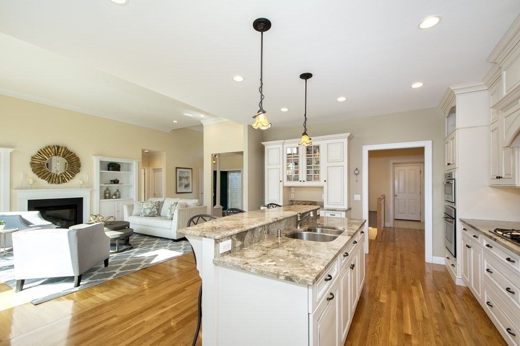 7 Tillinghast Drive, Unit 7 Hingham, MA 02043 - Photo 7 of 42 a view of a kitchen counter top space with fireplace wooden floor and windows