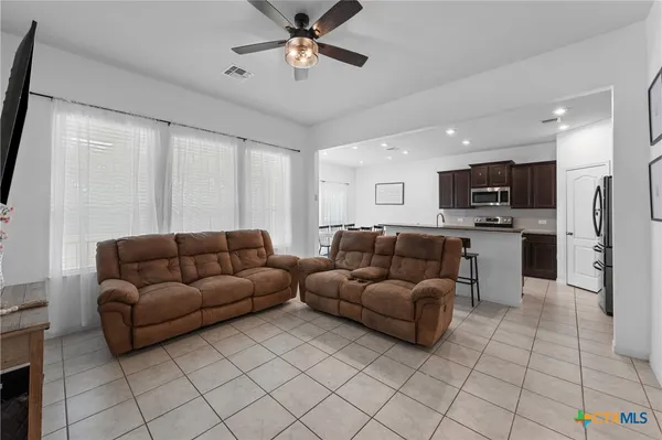 a living room with furniture and kitchen view