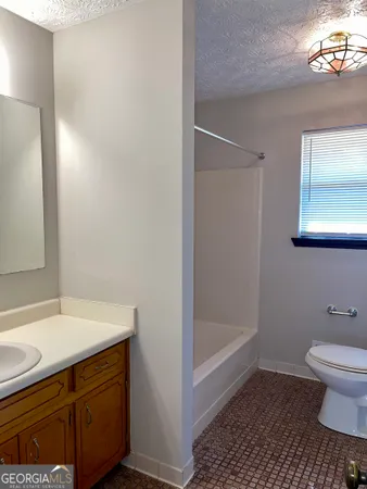 a bathroom with a sink a toilet a shower and a mirror