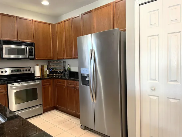 a kitchen with stainless steel appliances granite countertop a refrigerator stove and microwave
