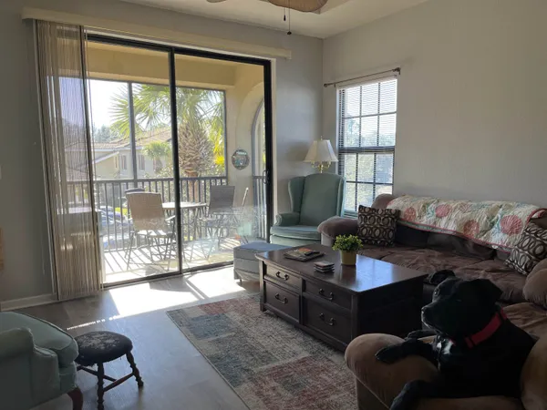 a living room with furniture and a floor to ceiling window