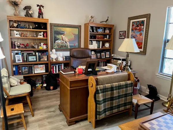 a bedroom with a workspace and a bookshelf