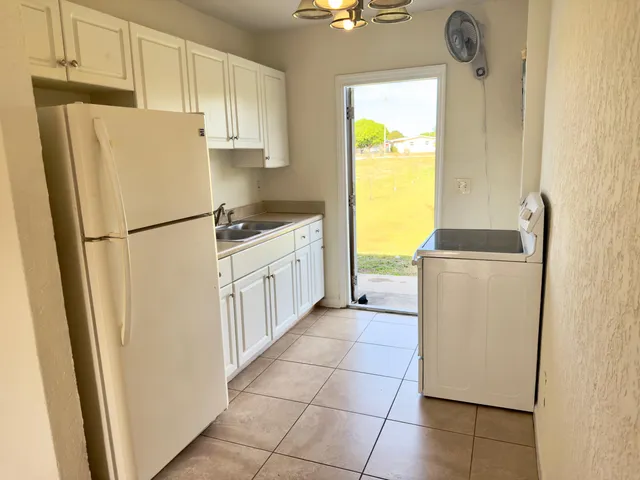 a white refrigerator freezer and a stove sitting inside of a kitchen
