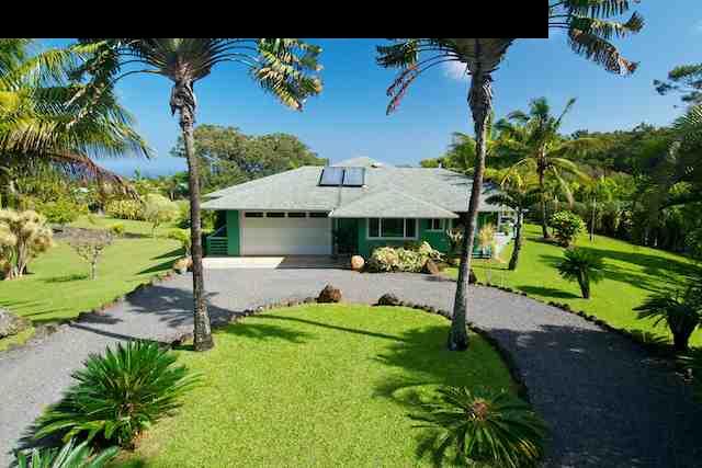 a view of a house with backyard and a garden