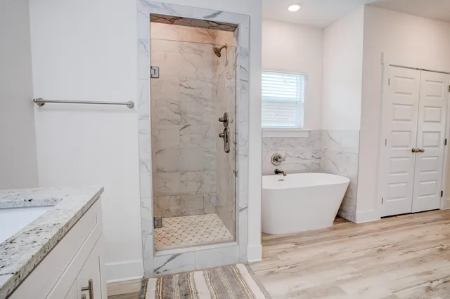 a bathroom with a granite countertop sink a bathtub and shower