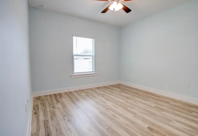 wooden floor in an empty room with a window