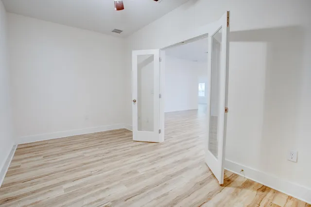 a view of an empty room with wooden floor