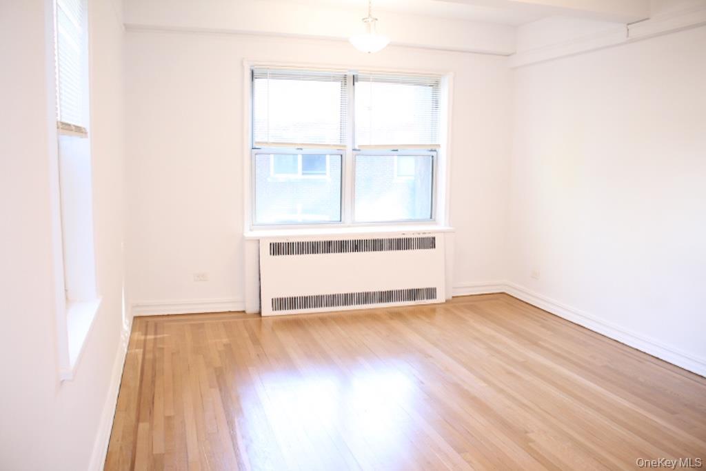 766 Palmer Road, Unit 2F Bronxville, NY 10708 - Photo 4 of 22 Empty room featuring radiator and light wood-style flooring