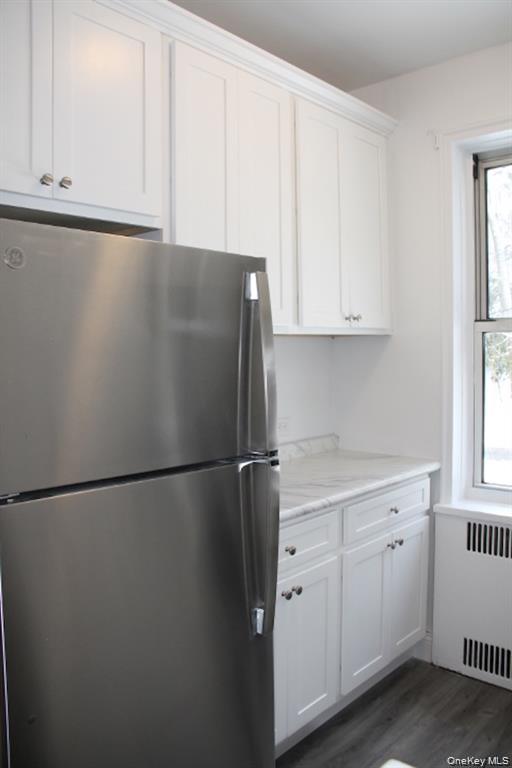 766 Palmer Road, Unit 2F Bronxville, NY 10708 - Photo 5 of 22 Kitchen featuring freestanding refrigerator, radiator, white cabinets, and dark wood-style flooring