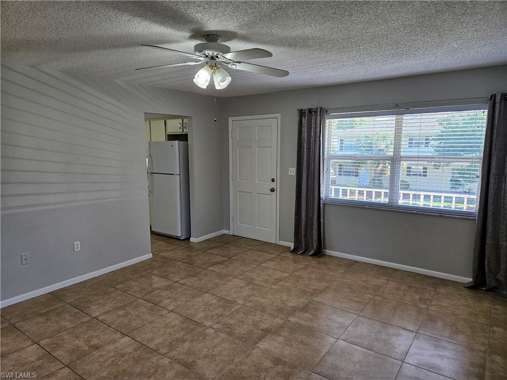 3325 Airport-Pulling Road, Unit D7 Naples, FL 34105 - Photo 6 of 17 Tiled empty room featuring a textured ceiling and ceiling fan