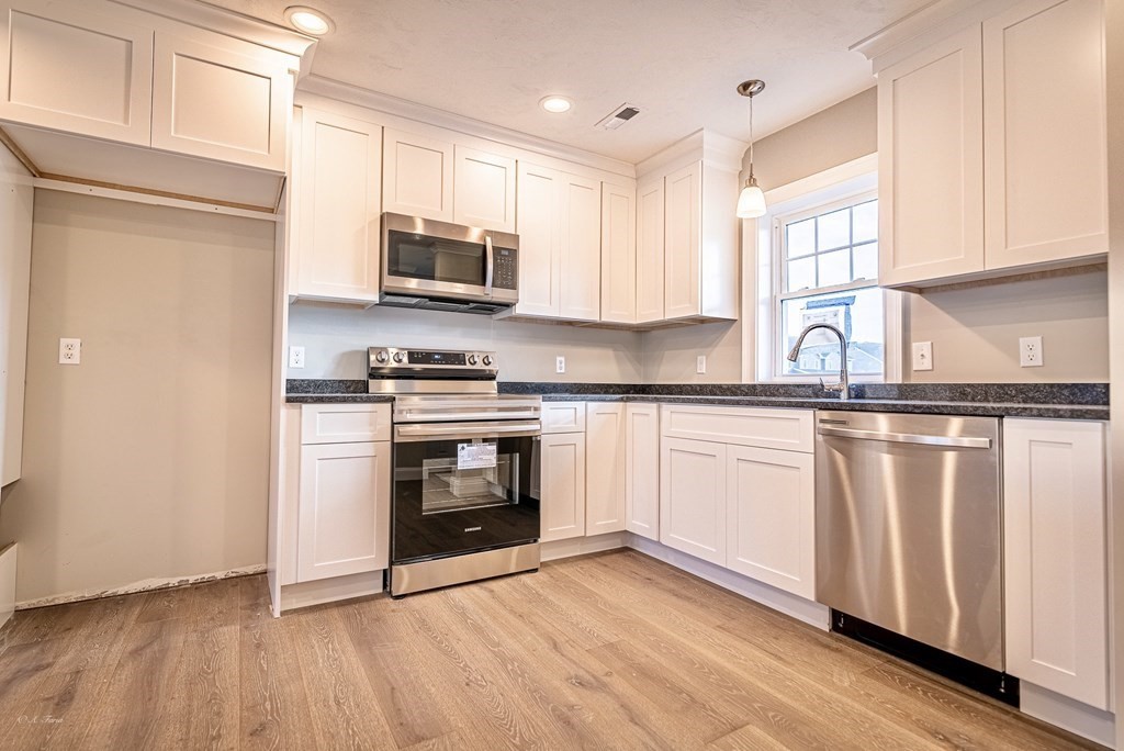 49 Riverside Drive, Unit 49A Lakeville, MA 02347 - Photo 6 of 31 a kitchen with granite countertop a sink cabinets stainless steel appliances and a window