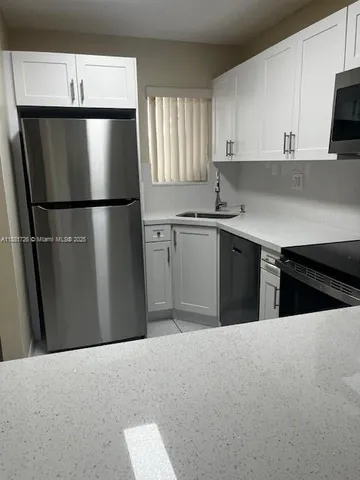 a kitchen with a refrigerator and a sink