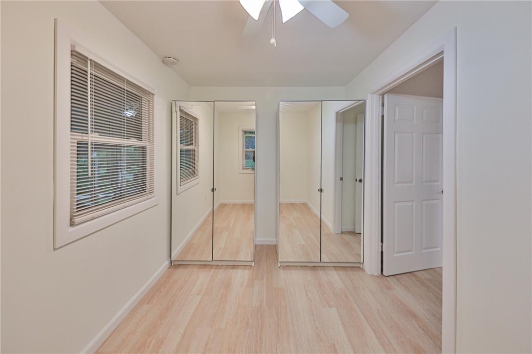 5599 Minks Pond Road Bushkill, PA 18324 - Photo 29 of 64 Well-lit room with wood flooring, ceiling fan, and ample mirrored closet space.