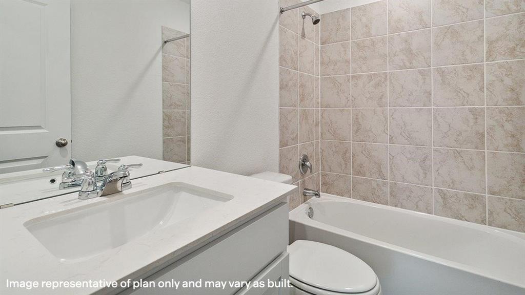 3522 Spring Time Street Forney, TX 75126 - Photo 24 of 27 Bathroom featuring a white vanity with integrated sink, chrome faucet, wall-mounted mirror, white bathtub, and light-toned tile shower surround