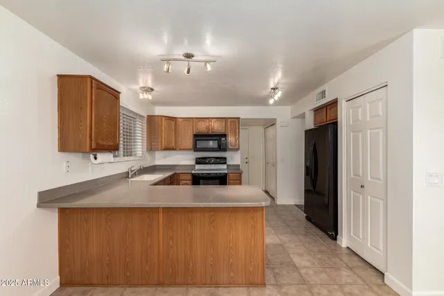 a kitchen with stainless steel appliances granite countertop a sink refrigerator and cabinets