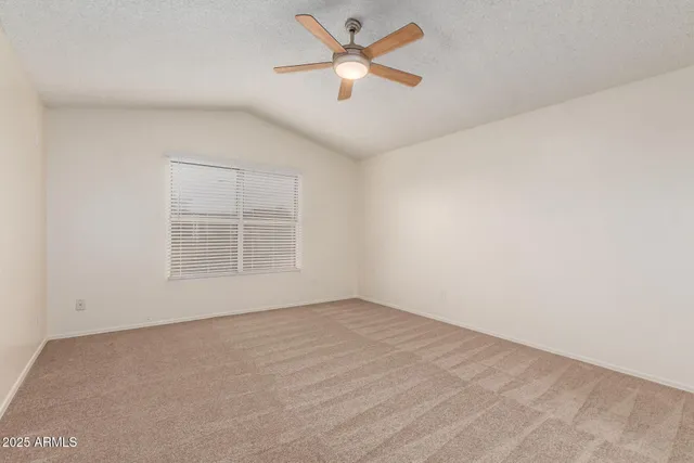 an empty room with a window and a ceiling fan