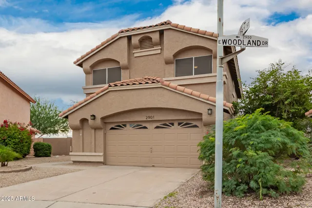 a view of a white house with a clock on the side of it