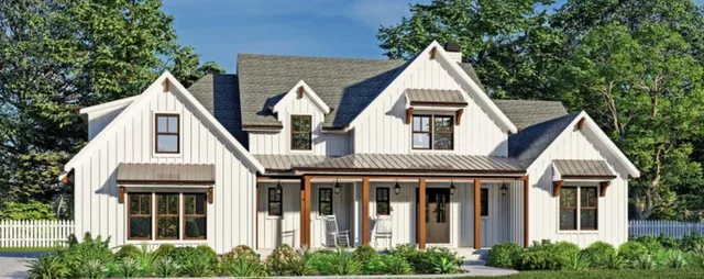 a view of a white house with large windows and a small yard