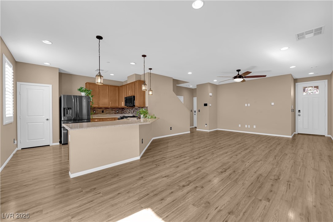 915 Harbor Avenue Henderson, NV 89002 - Photo 32 of 32 Kitchen with decorative light fixtures, open floor plan, stainless steel fridge, a ceiling fan, and light wood finished floors
