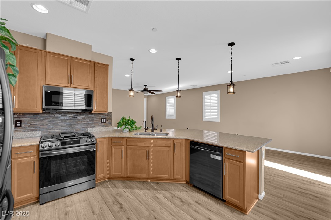 915 Harbor Avenue Henderson, NV 89002 - Photo 5 of 32 Kitchen featuring appliances with stainless steel finishes, hanging light fixtures, tasteful backsplash, recessed lighting, and light wood finished floors