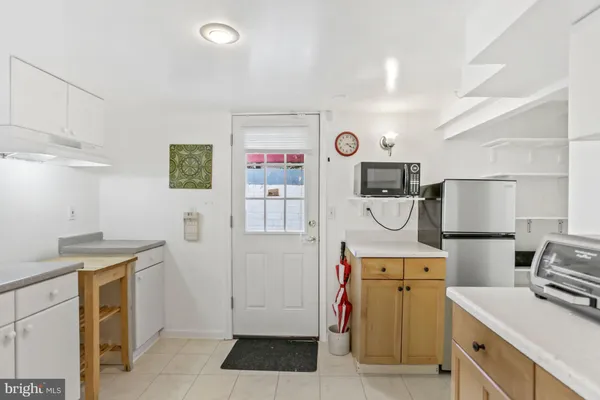a very nice looking kitchen with a large window wooden floor and stainless steel appliances