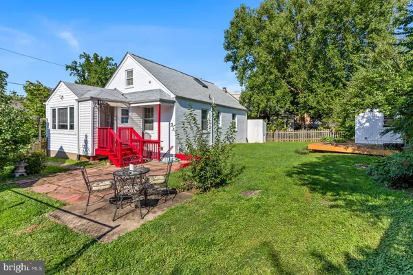 a view of backyard with a barn and large trees