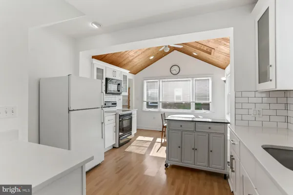 a kitchen with a refrigerator sink and cabinets