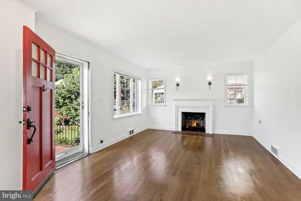 a view of an empty room with window and fire place