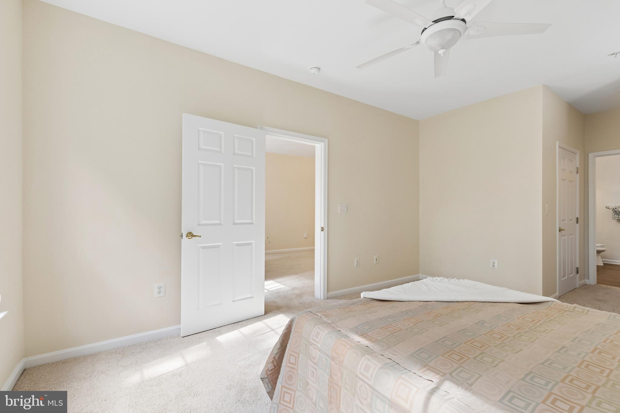 431 Hamlet Club Drive, Unit 102 Edgewater, MD 21037 - Photo 25 of 55 a bedroom with a bed and a chandelier fan