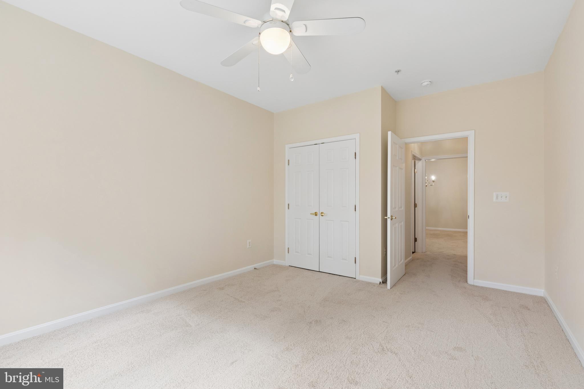 431 Hamlet Club Drive, Unit 102 Edgewater, MD 21037 - Photo 30 of 55 an empty room with a ceiling fan and a window