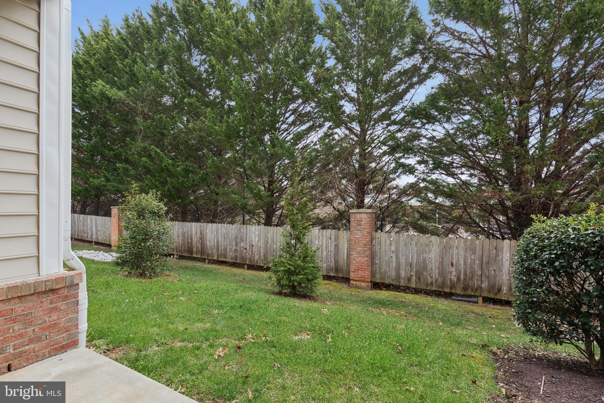 431 Hamlet Club Drive, Unit 102 Edgewater, MD 21037 - Photo 42 of 55 a view of a backyard with large trees and wooden fence