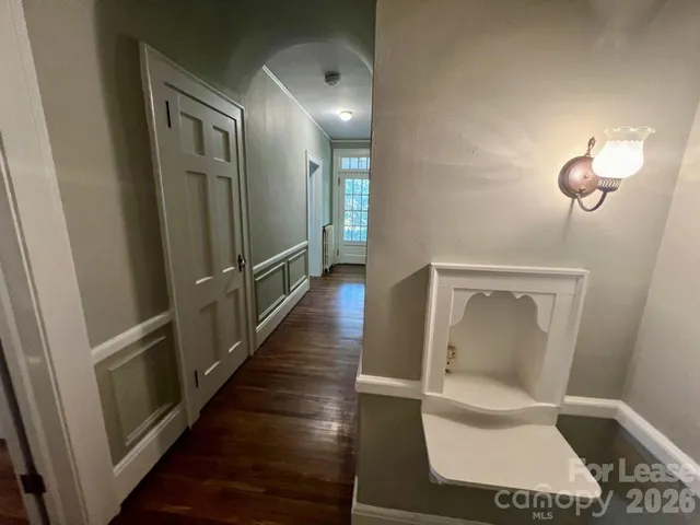 a view of a hallway with wooden floor and staircase