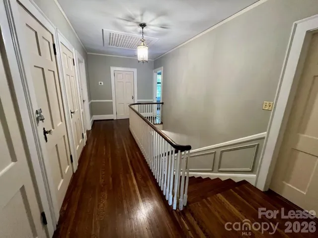 a view of a hallway with wooden floor and staircase