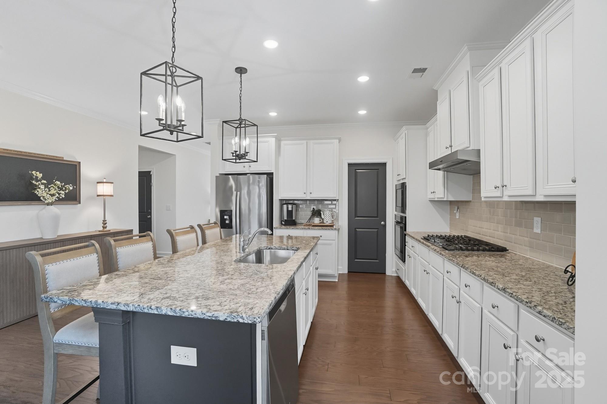 2048 Poplar Ridge Drive Monroe, NC 28110 - Photo 12 of 44 a kitchen with granite countertop kitchen island stainless steel appliances a stove a sink a center island and cabinets