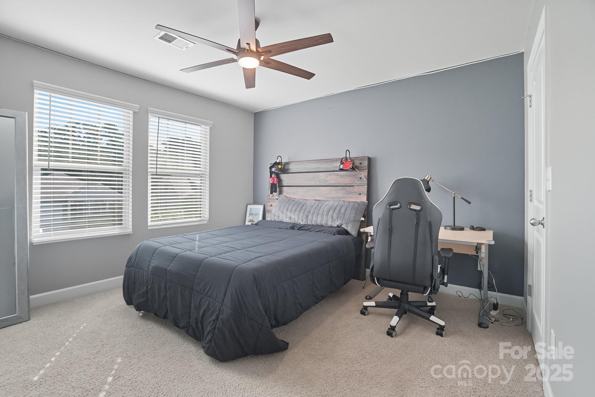 2048 Poplar Ridge Drive Monroe, NC 28110 - Photo 26 of 44 a bedroom with a bed a desk and chair with windows
